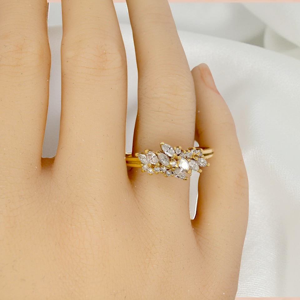 Gold ring with diamonds on a hand against a white background