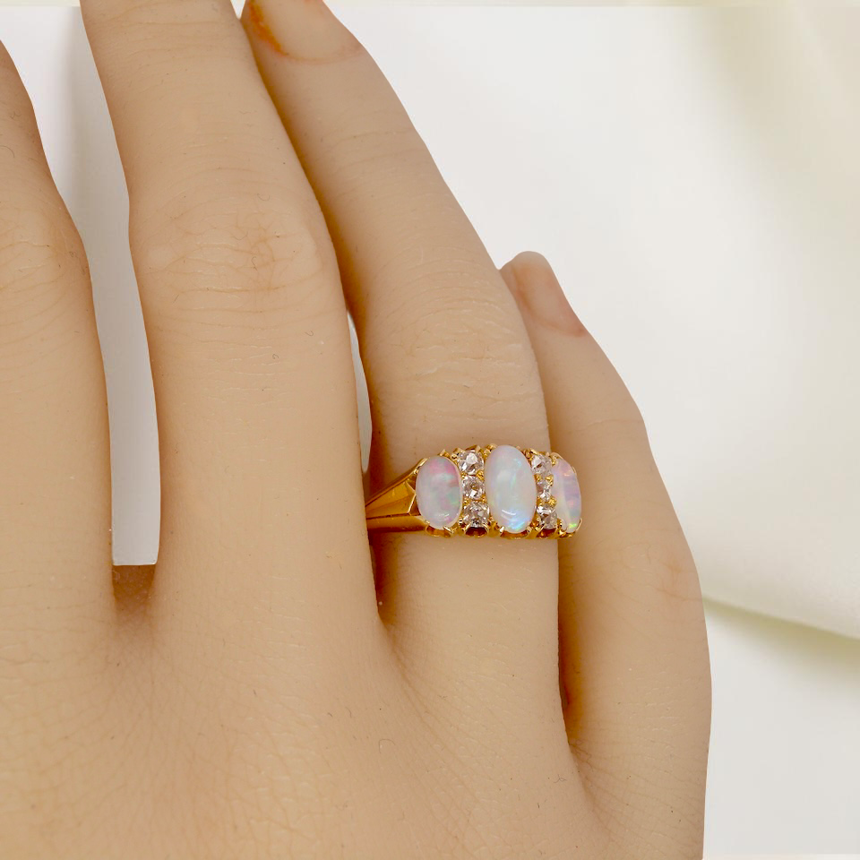 hand A beautiful Victorian dress ring, set with three finely matched oval opals,
