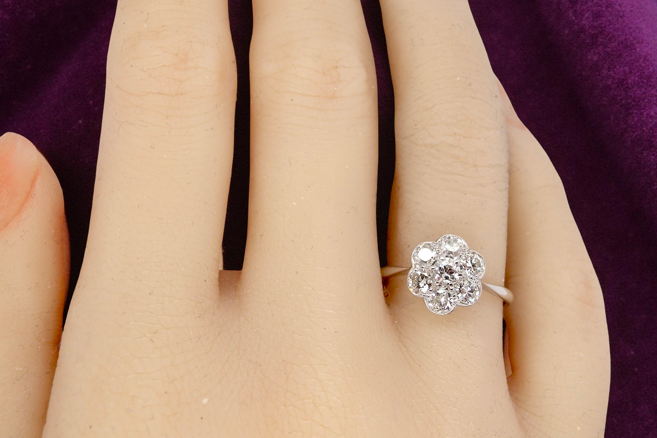 Diamond ring on a person's finger with a purple background