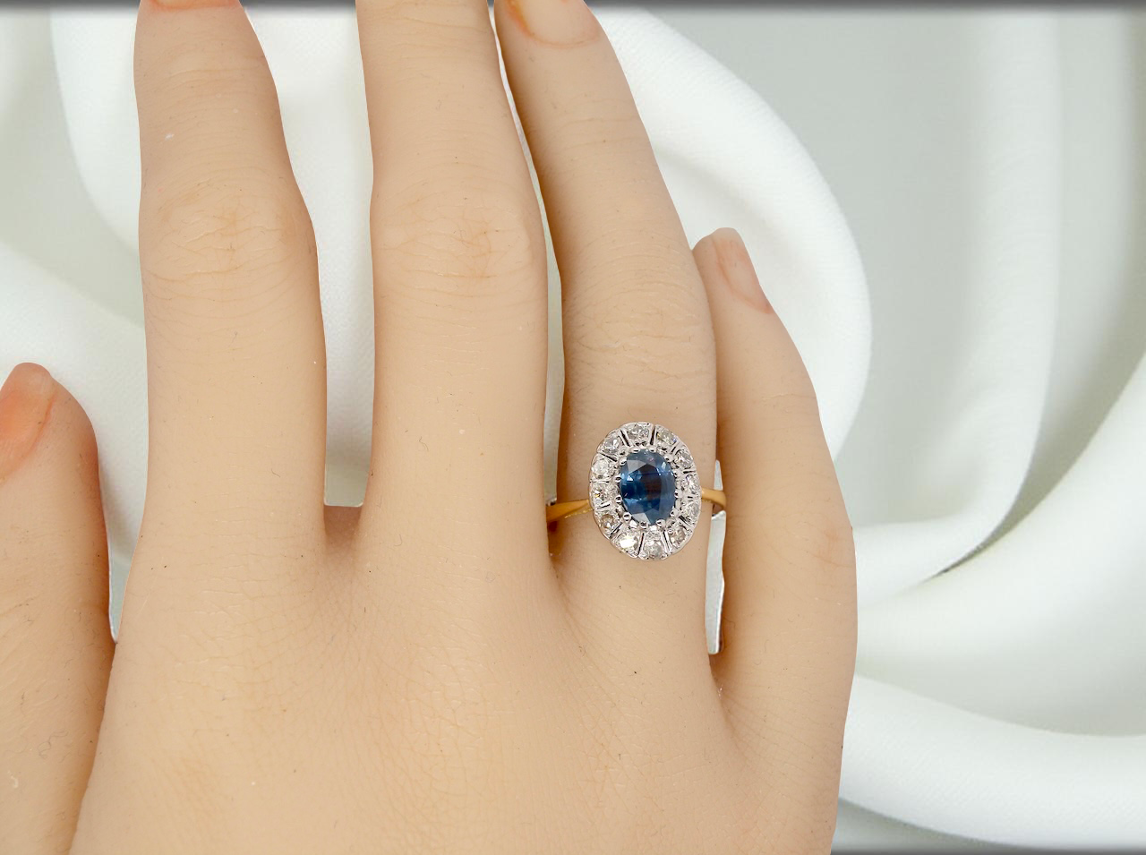 A beautiful vintage cluster ring featuring an oval sapphire