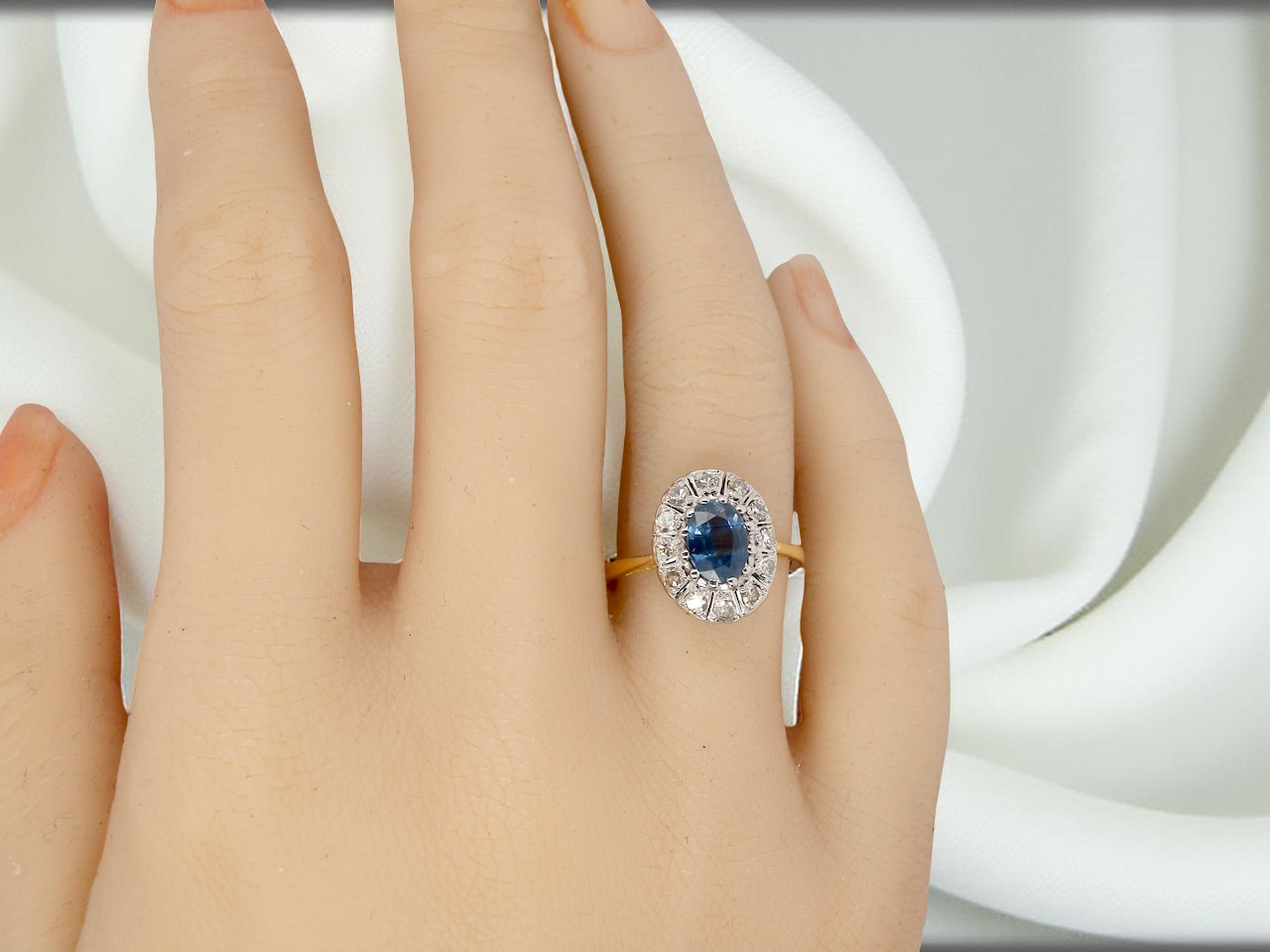 A beautiful vintage cluster ring featuring an oval sapphire