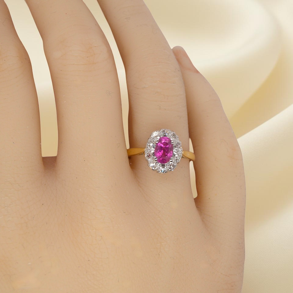 hand A beautiful vintage cluster ring showcasing a vivid pink sapphire centre stone, measuring approximately 6.6 × 4.3 mm(estimated 0.65 carats).