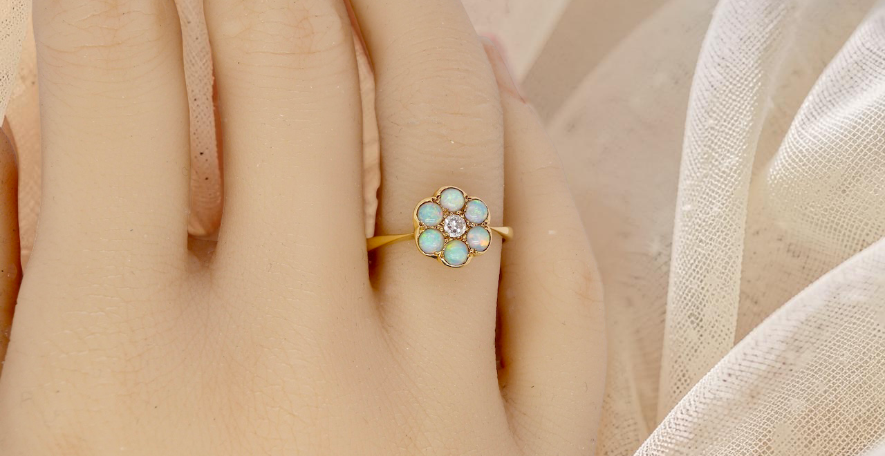 hand A daisy cluster dress ring. Set with a small diamond centre stone, diameter 3mm (0.10 carats)