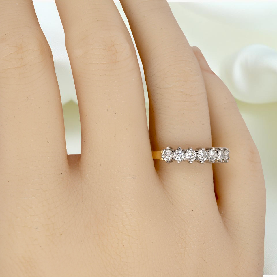 hand A fine 18 carat gold half hoop eternity ring, beautifully set with an array of seven brilliant-cut white diamonds.
