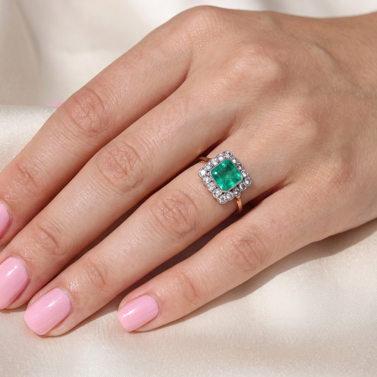 hand A fine Art Deco emerald and diamond cluster ring, beautifully proportioned and displaying all the elegance associated with the period.