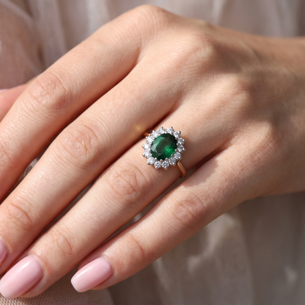 hand A fine and impressive vintage cluster ring, centred with a striking oval-cut deep dark green tourmaline, measuring 9 x 7mm and estimated to weigh approximately 2.00 carats.