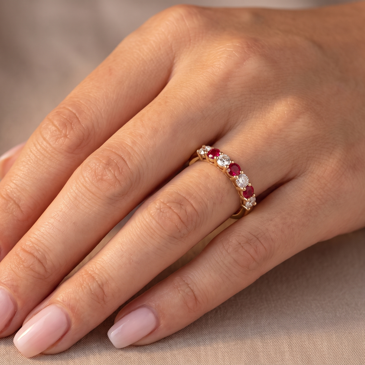 hand A fine half hoop ring. 18 carat gold set with three rubies, each 3.8mm (est 0.20 carats, total 0.67 carats) and four brilliant cut white diamonds, each 3.8mm (total 0.85 carats) 