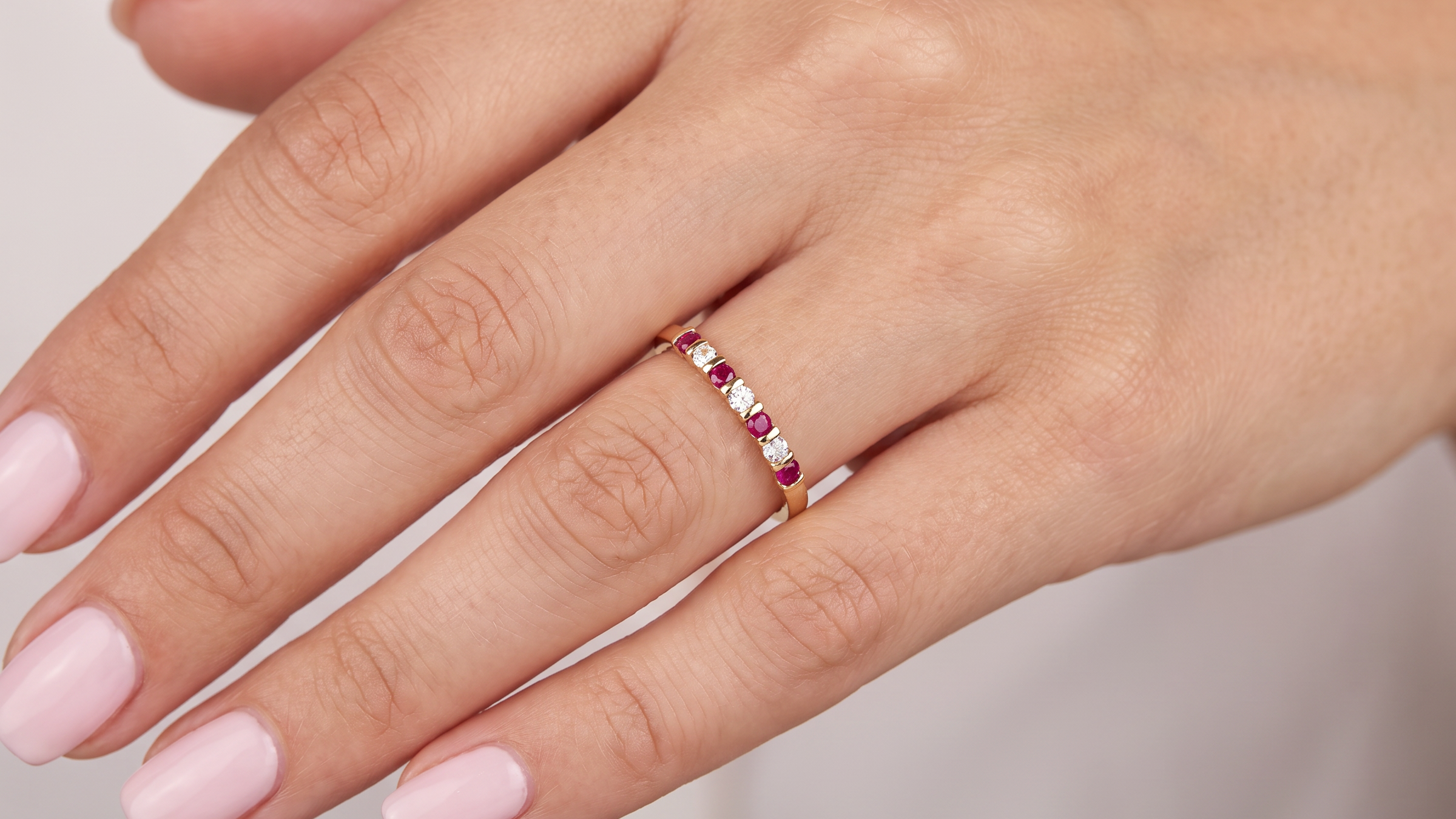 hand A half hoop 18 carat yellow gold eternity ring. Set with four bright red rubies, each 2.6mm (total carat weight 0.28 est)