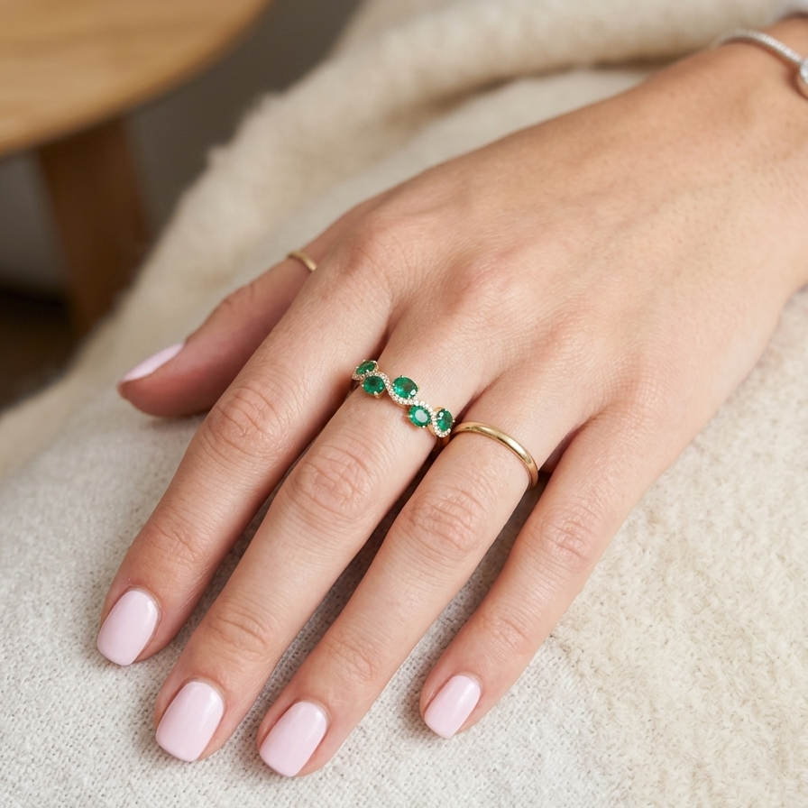 hand A half hoop ring with a very attractive line of oval cut emeralds, each 4x3mm, a lovely deep grass green hue, and with very good clarity too.