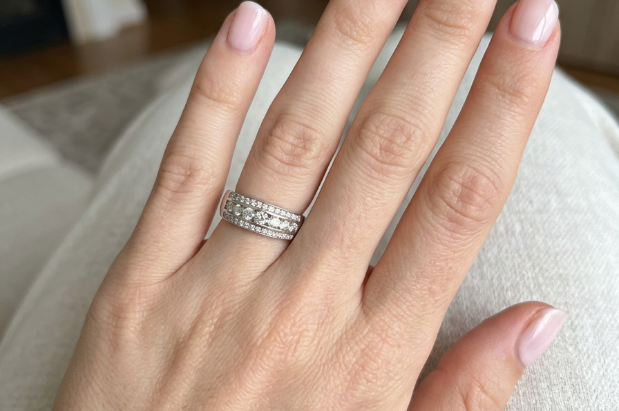 hand A lovely 18 carat white gold half hoop ring. Set with a middle row of nine bright white brilliant cut diamonds, graduate from 2.2mm to 2.6mm. The top and bottom rows are also set with small diamonds.