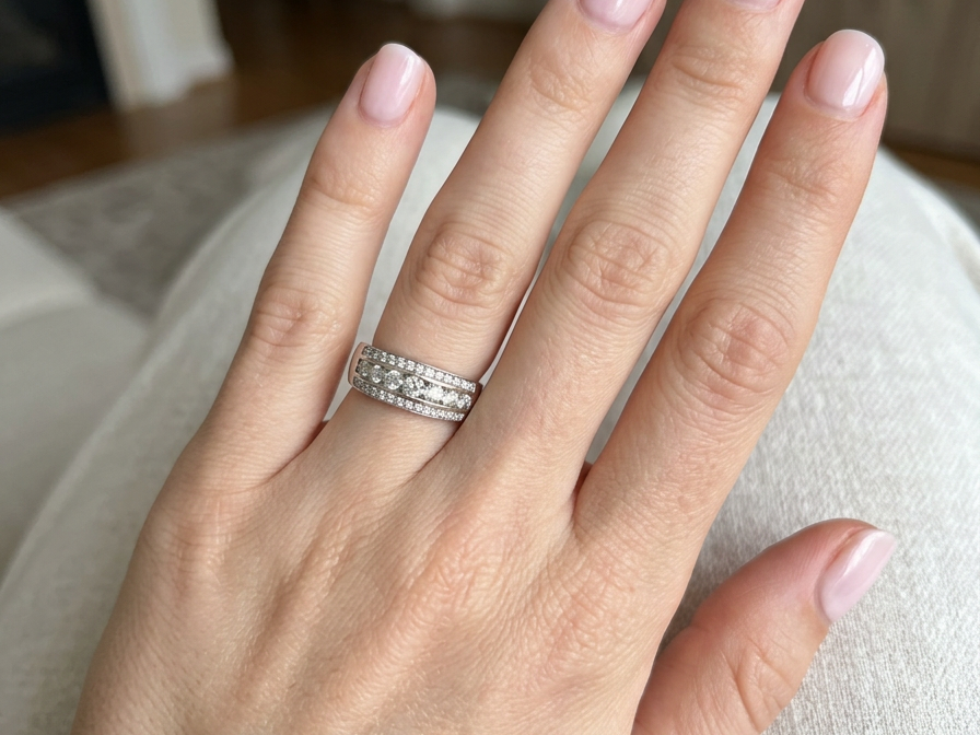 hand A lovely 18 carat white gold half hoop ring. Set with a middle row of nine bright white brilliant cut diamonds, graduate from 2.2mm to 2.6mm. The top and bottom rows are also set with small diamonds.
