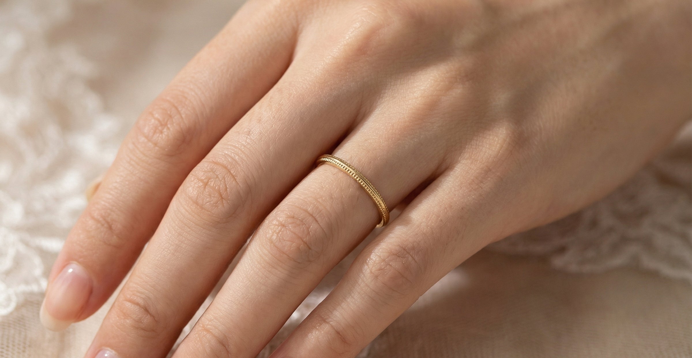 hand A narrow 18 carat gold wedding ring bead pattern