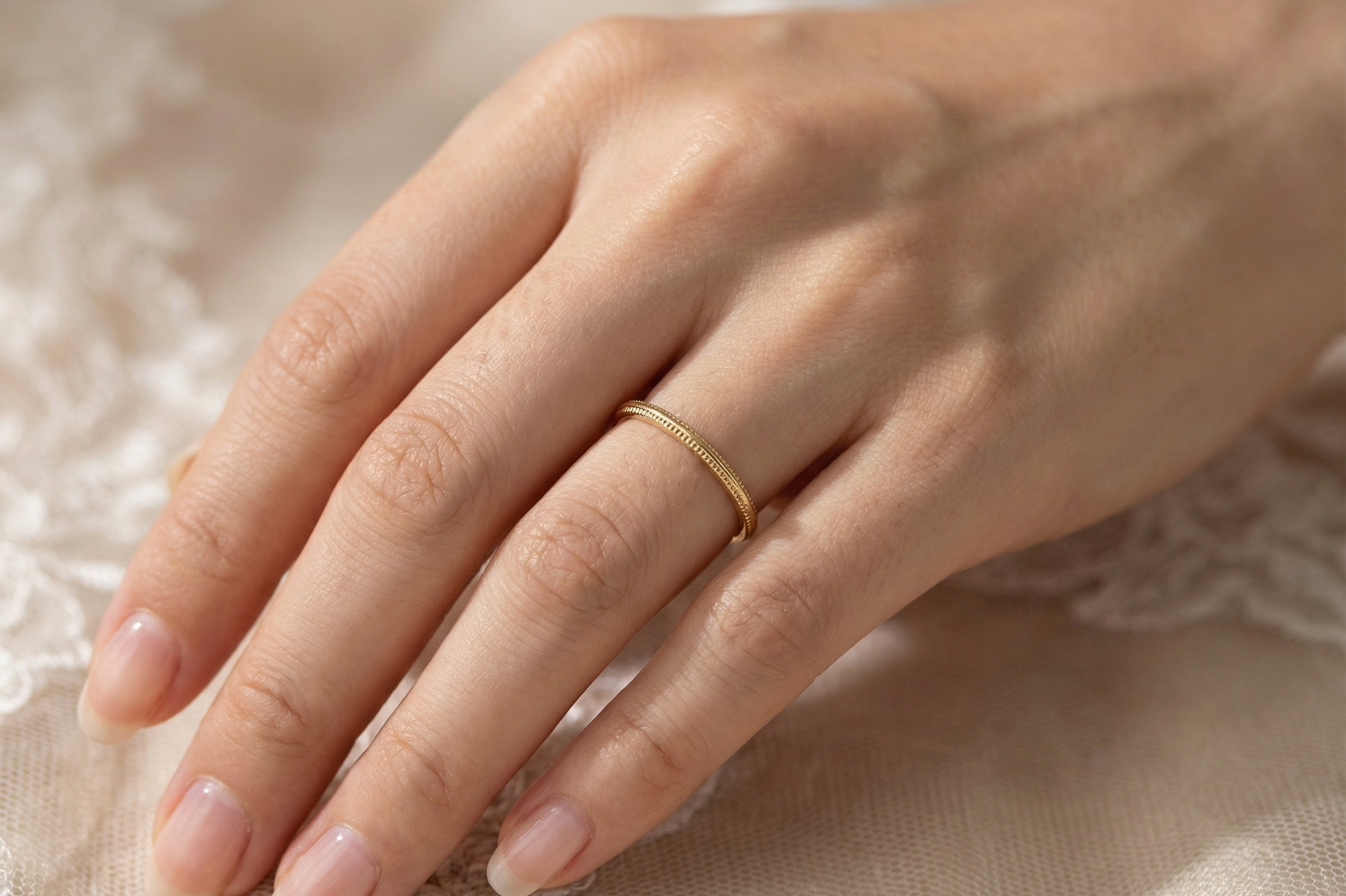 hand A narrow 18 carat gold wedding ring bead pattern
