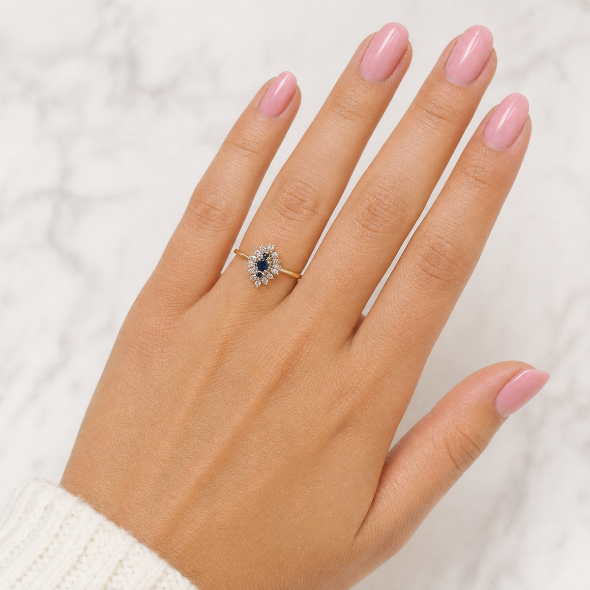 hand A navette shaped cluster ring. The centre a line of three sapphires, 0ne x 3.5mm, 2 x 1.5mm.