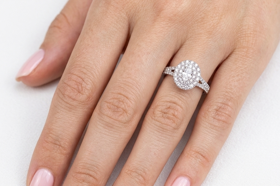 hand A new diamond cluster ring* An oval diamond halo cluster ring. Set with brilliant cut white diamonds, colour H-k, clarity Si.