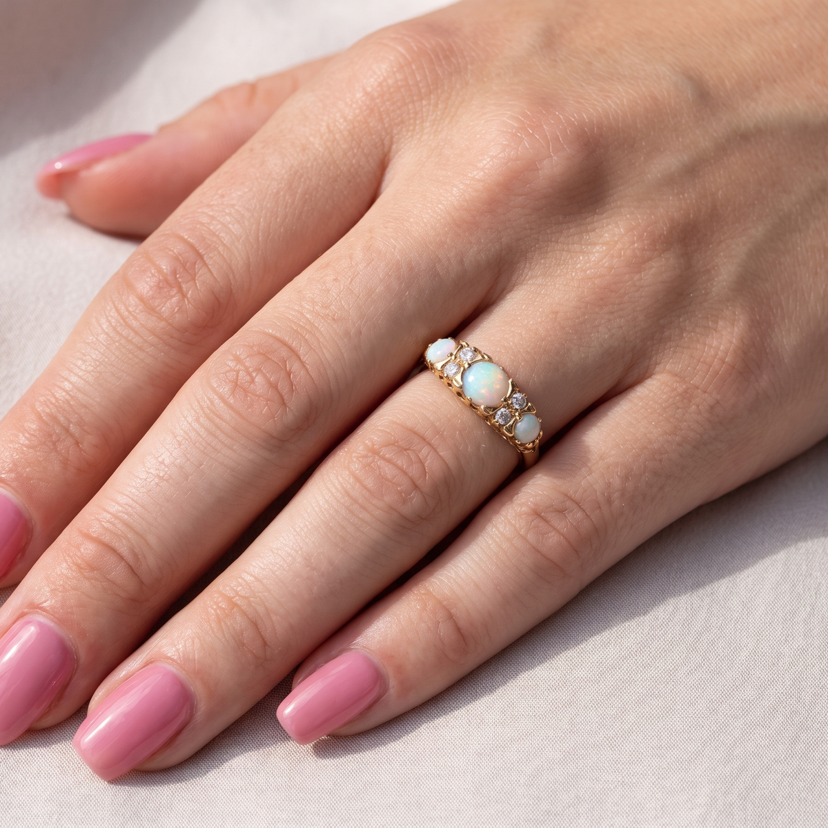 hand A pretty Victorian style ring. 18 carat gold. There are three opals, centre 6mm, each end 4x3mm. Good colour play