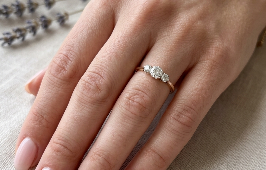 hand A pretty three stone trilogy ring that features three brilliant cut white diamonds.
Centre diamond, 5mm (est 0.50 carats) each side a 4mm diamond (est 0.25 carats). Colour G-h, clarity Si. Platinum rim style setting, head measures 12.7x5.3mm, depth 5.3mm, weight 2.4grams.