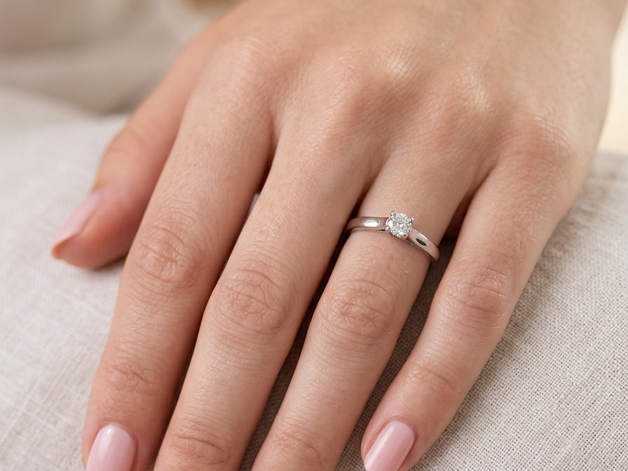 hand A single stone solitaire diamond ring. The modern brilliant cut white diamond measures 3.9mm (0.22 carats est) Colour G-h, clarity VS.