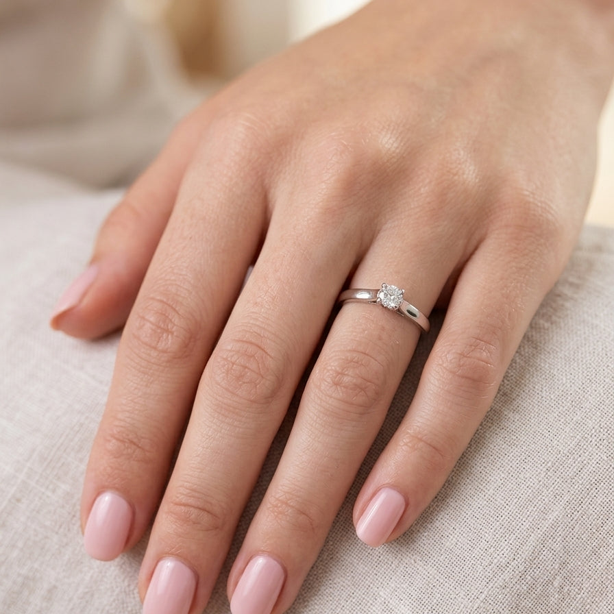 hand A single stone solitaire diamond ring. The modern brilliant cut white diamond measures 3.9mm (0.22 carats est) Colour G-h, clarity VS.