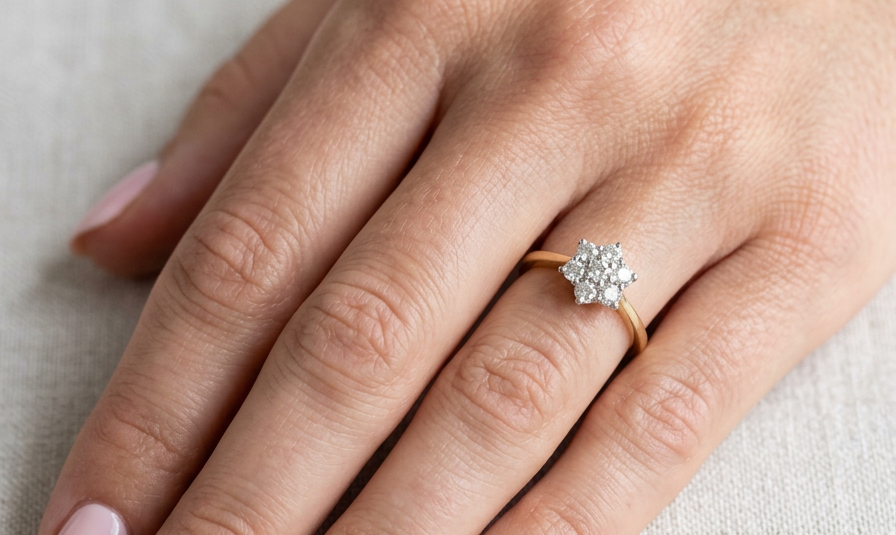 hand A small cluster ring set with seven bright white brilliant cut white diamonds.
Head measures 8.5mm, each diamond measures 2.8mm (total 0.50 carats