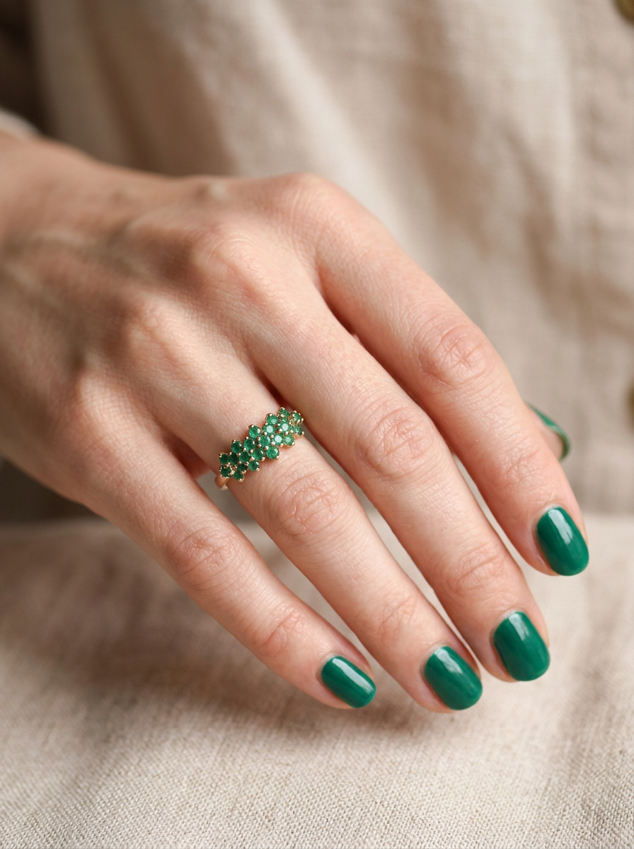 hand A striking and unusual dress ring, designed with multiple clusters of round-cut emeralds set beautifully across the finger for a bold, eye-catching look.