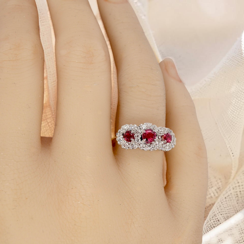 hand A striking triple cluster ring crafted in 18 carat gold, dating circa 1990–2000, and fully hallmarked in the UK.
✨ Design & Gemstones
Three deep red rubies set to the centre of each cluster