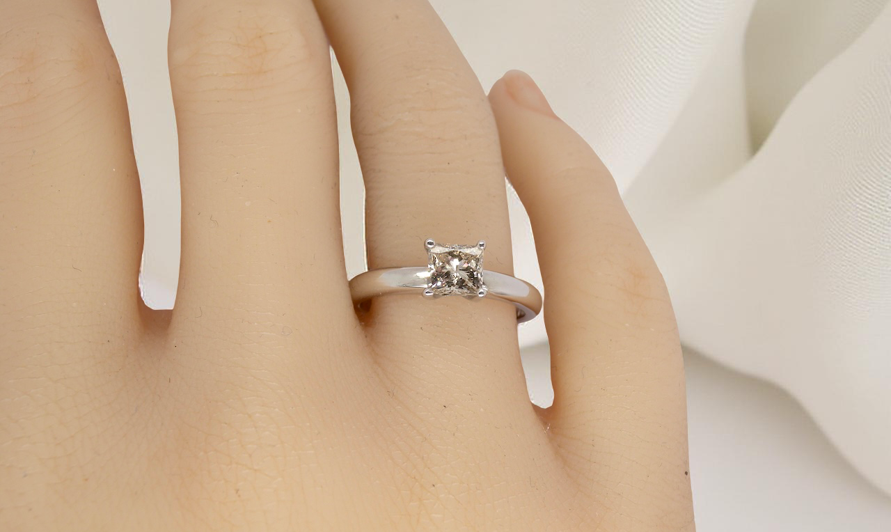 hand A timeless and beautifully crafted solitaire ring featuring a stunning 0.78 carat Princess-cut white diamond