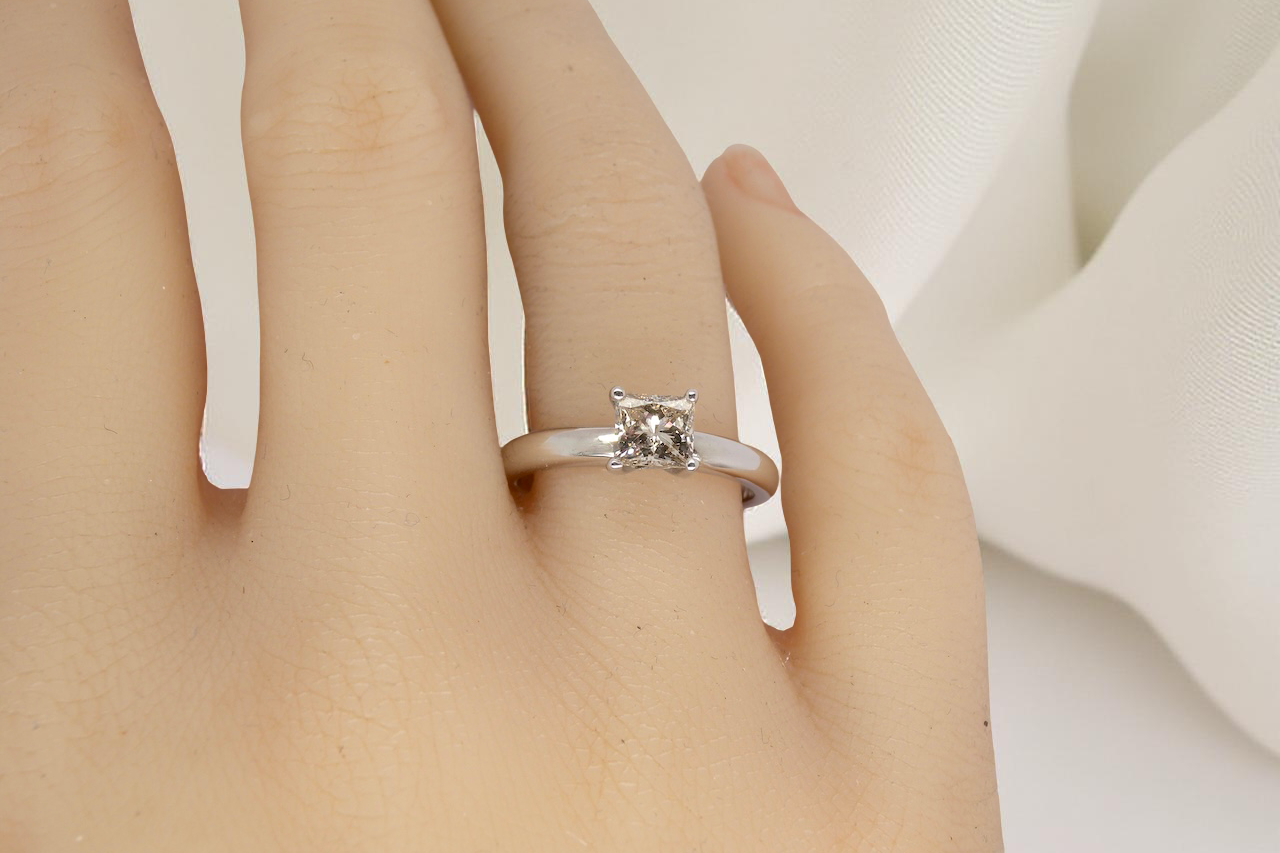 hand A timeless and beautifully crafted solitaire ring featuring a stunning 0.78 carat Princess-cut white diamond