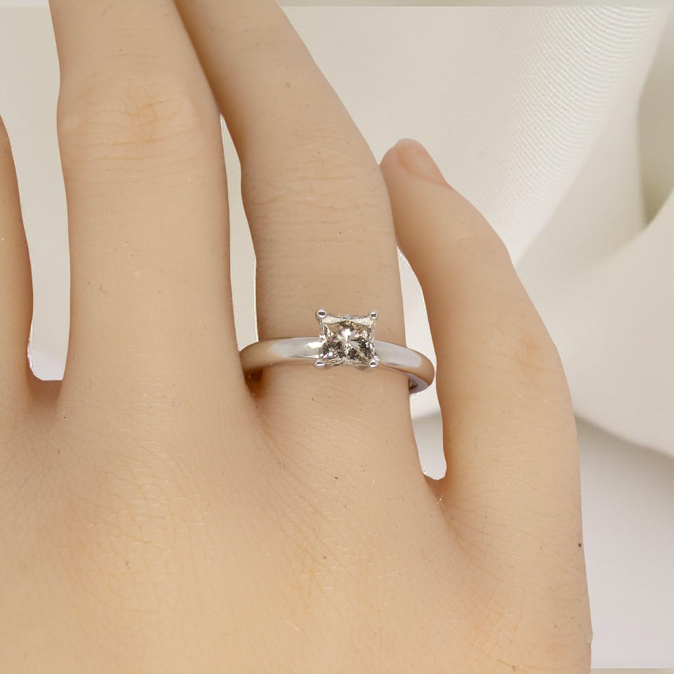 hand A timeless and beautifully crafted solitaire ring featuring a stunning 0.78 carat Princess-cut white diamond