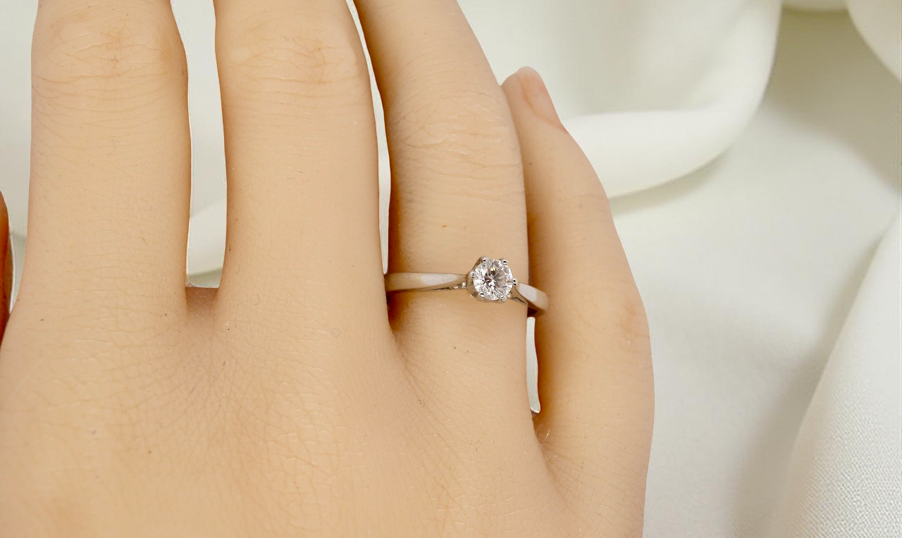 hand A timeless and elegant solitaire ring set with a brilliant-cut white diamond
