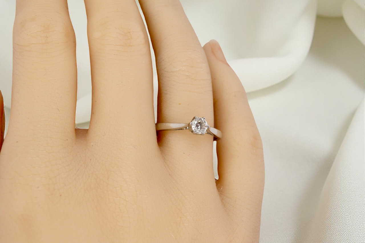 hand A timeless and elegant solitaire ring set with a brilliant-cut white diamond