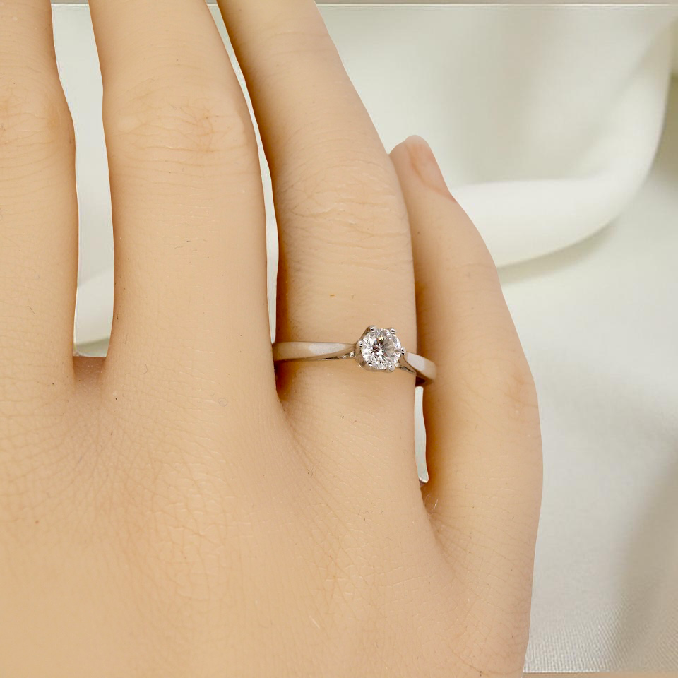 hand A timeless and elegant solitaire ring set with a brilliant-cut white diamond