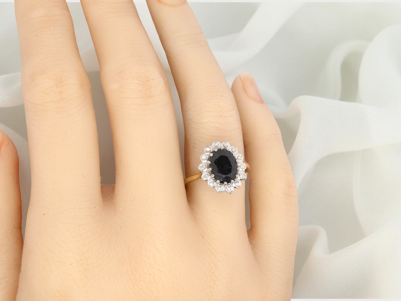 hand A timeless cluster ring featuring a deep ink-black blue sapphire