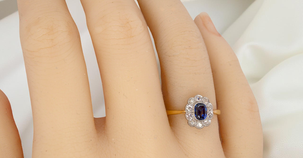 hand A traditional 1970s cluster ring featuring a rectangular-cut sapphire,