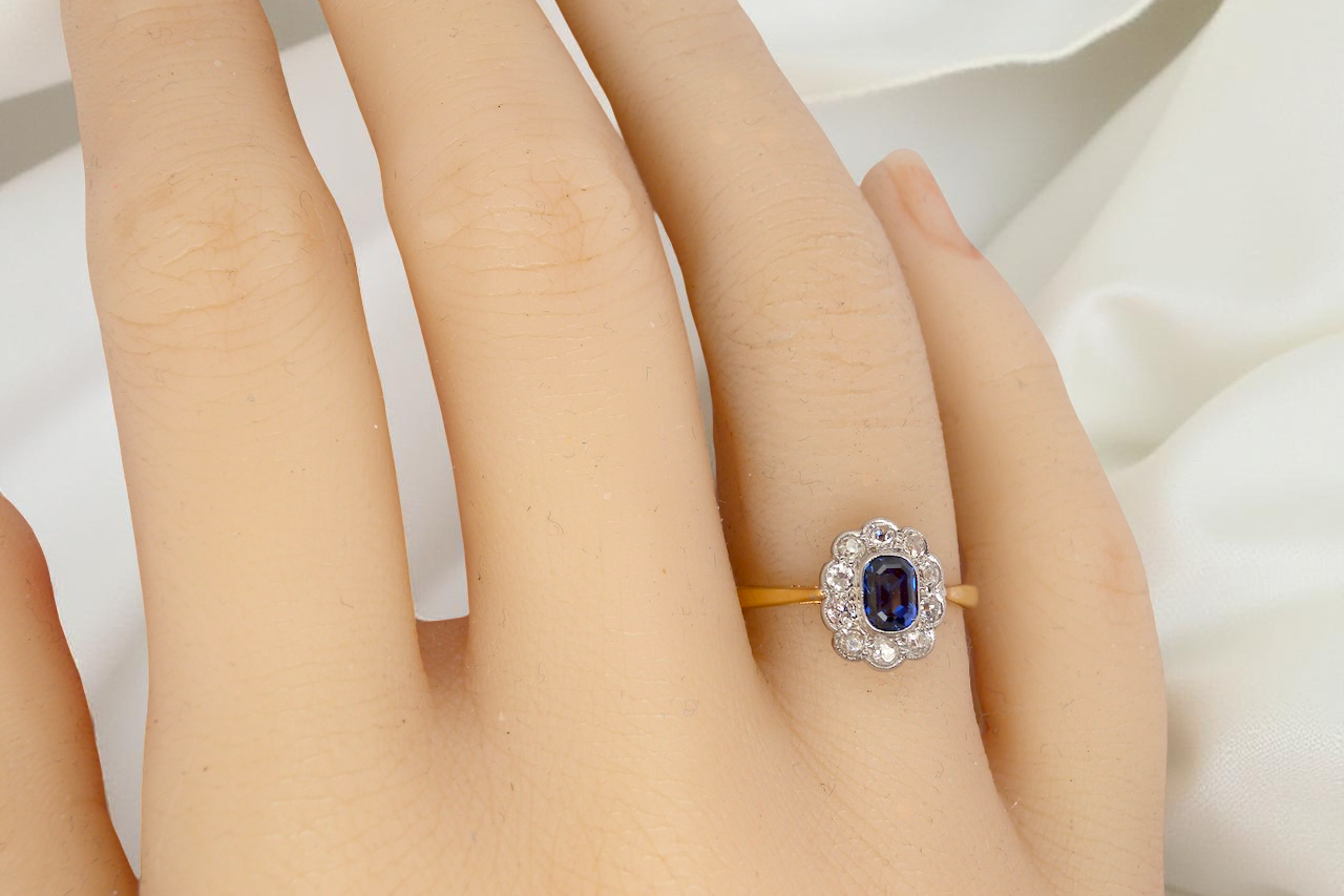 hand A traditional 1970s cluster ring featuring a rectangular-cut sapphire,