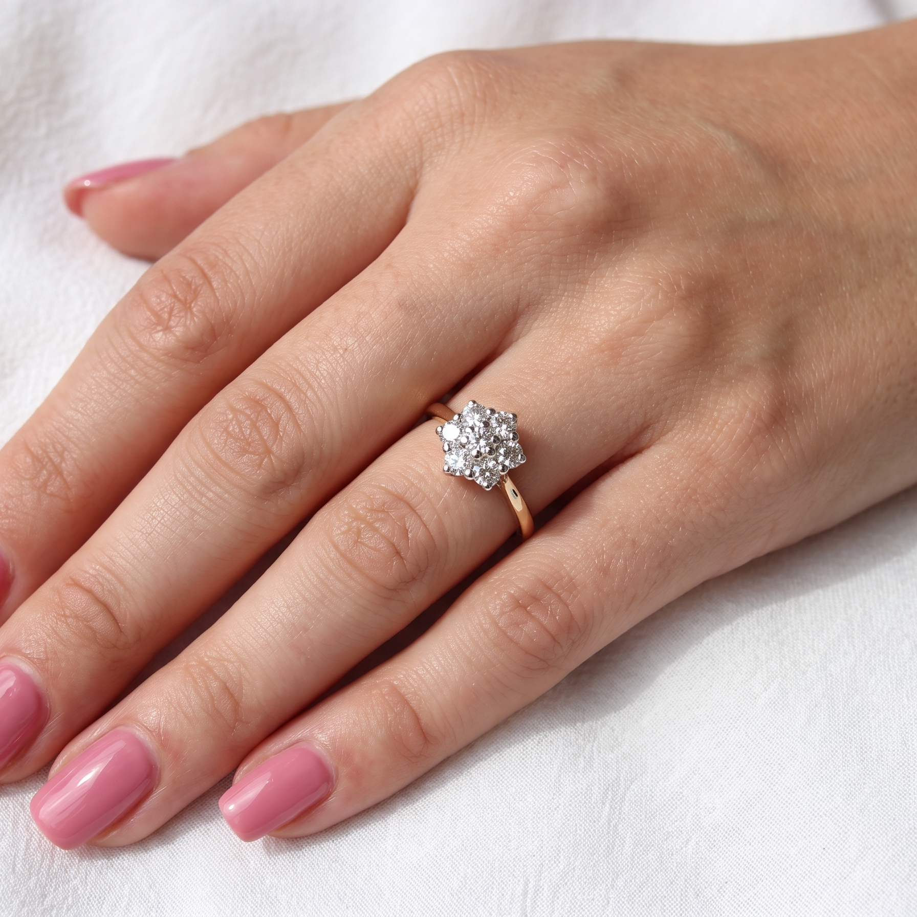 hand A traditional cluster ring. Features to the centre a 3.4mm brilliant cut white diamond (est 0.15 carats)
Surrounded by six 3.4mm diamonds to match