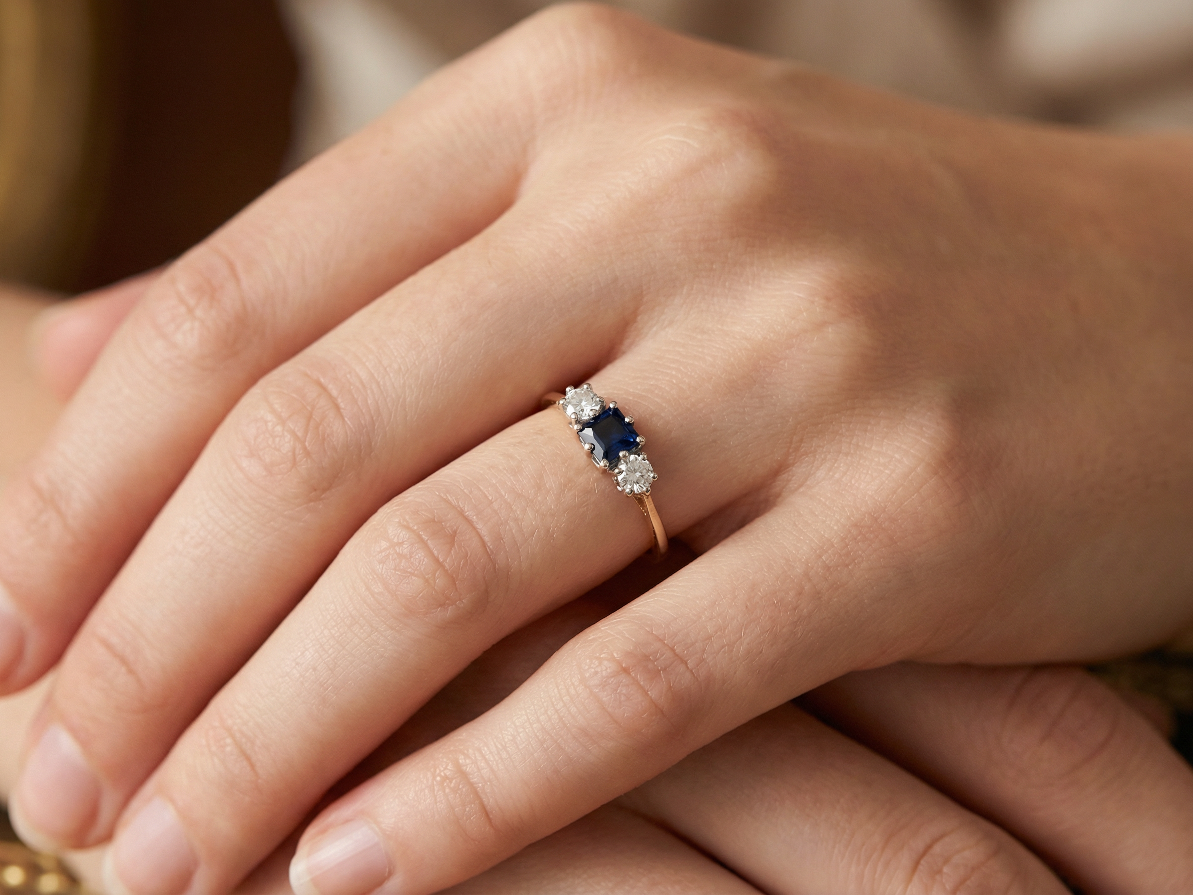 hand A vintage 1950s three stone ring. Centre stone an ink black blue sapphire, measures 4x4mm (est 0.30 carats).