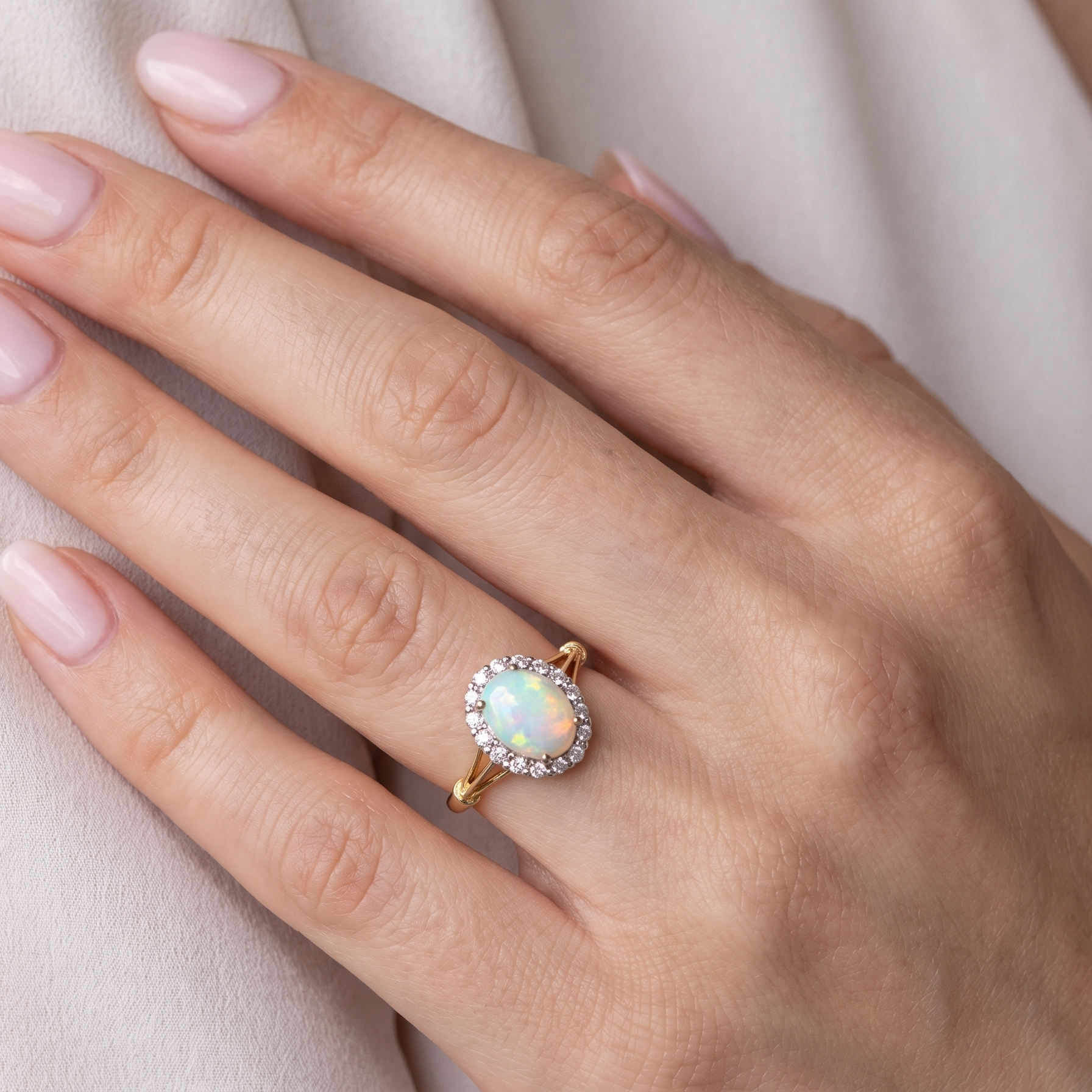 hand A vintage cluster ring. Features an oval white opal, measures 10x8mm, with a good play of colour.