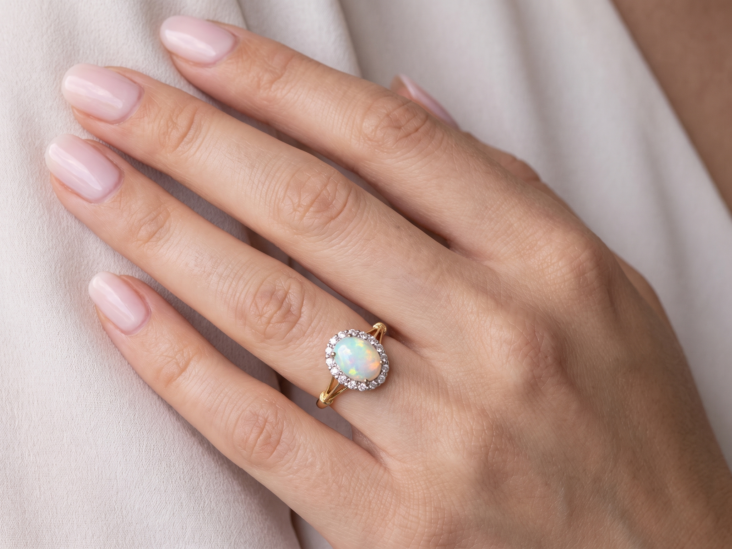 hand A vintage cluster ring. Features an oval white opal, measures 10x8mm, with a good play of colour.