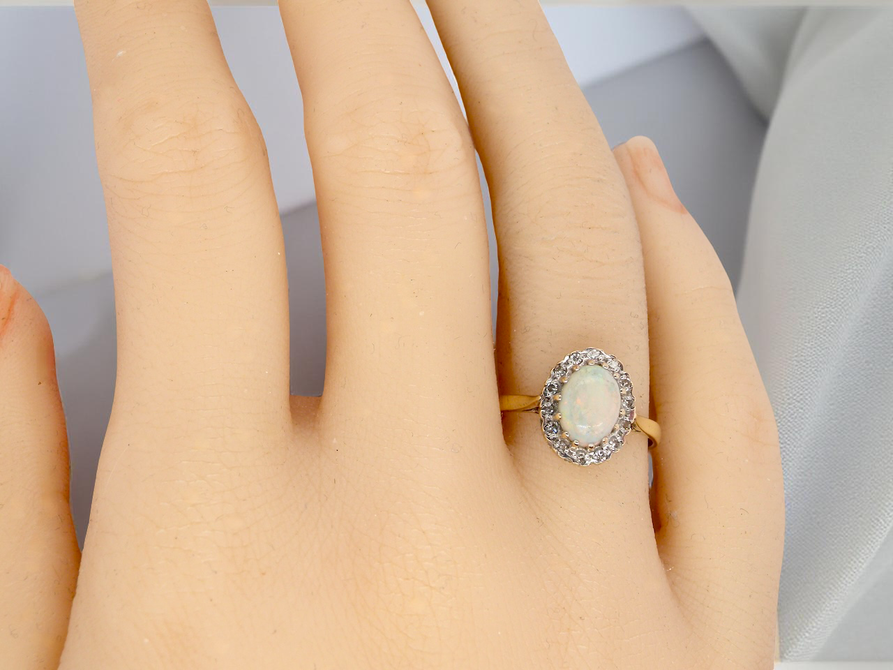 hand A vintage cluster ring set with an oval cabouchon cut opa