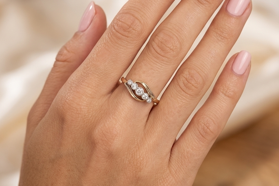 hand A vintage cross over style ring. Set with five old brilliant cut white diamonds. Centre stone 3mm, each side 2.4mm, each end 1.5mm. Total diamond content estimated at 0.22 carats.