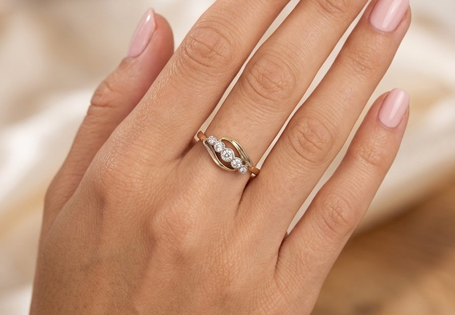 hand A vintage cross over style ring. Set with five old brilliant cut white diamonds. Centre stone 3mm, each side 2.4mm, each end 1.5mm. Total diamond content estimated at 0.22 carats.