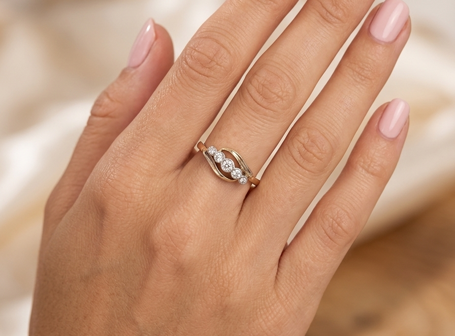 hand A vintage cross over style ring. Set with five old brilliant cut white diamonds. Centre stone 3mm, each side 2.4mm, each end 1.5mm. Total diamond content estimated at 0.22 carats.