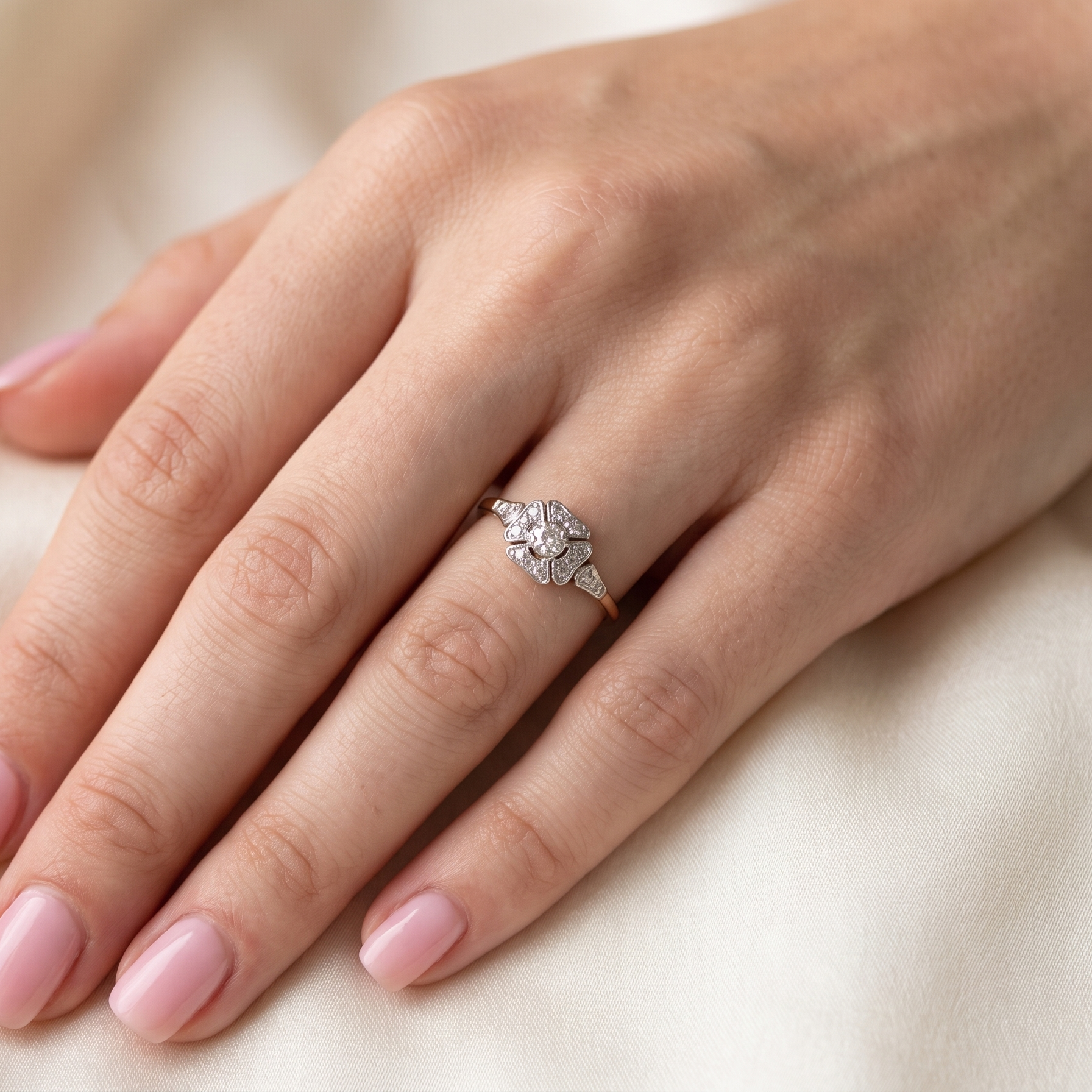 hand A vintage diamond cluster ring. Shaped like a four leaf clover, each leaf is pavé set with small white diamonds, two each x 1.5mm. Centre diamond 2.4mm. (total estimated total 0.17 carats)