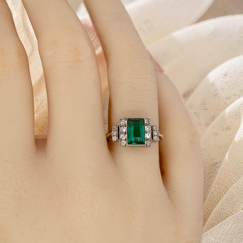 hand A vintage early 20th century dress ring. The centre stone a vibrant crystal clear green paste stone, 8x6mm.