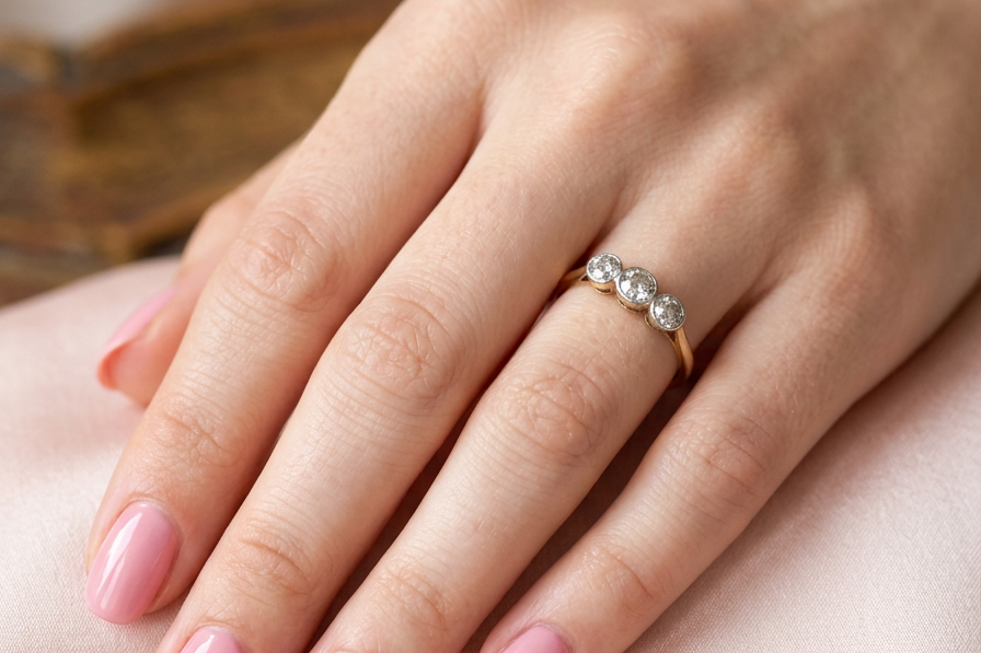 hand A vintage early 20th century trilogy ring. Set with three old cut diamonds, centre stone 3.8mm, and each side a 3.6mm diamond (total carat weight estimated at 0.55 carats)