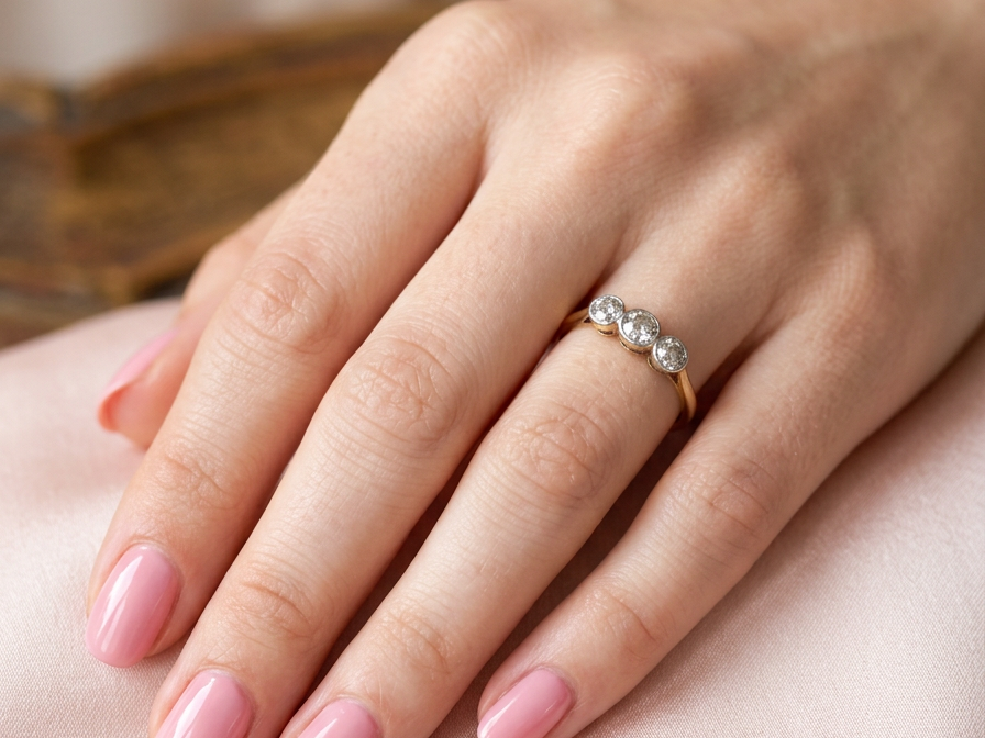 hand A vintage early 20th century trilogy ring. Set with three old cut diamonds, centre stone 3.8mm, and each side a 3.6mm diamond (total carat weight estimated at 0.55 carats)