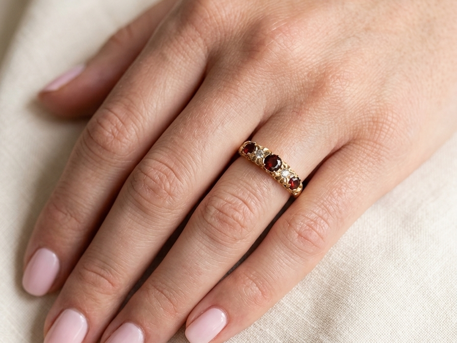 hand A vintage style 18 carat gold boat shaped ring. Features three dark red garnets, centre 4mm, each end a 3mm stone. 