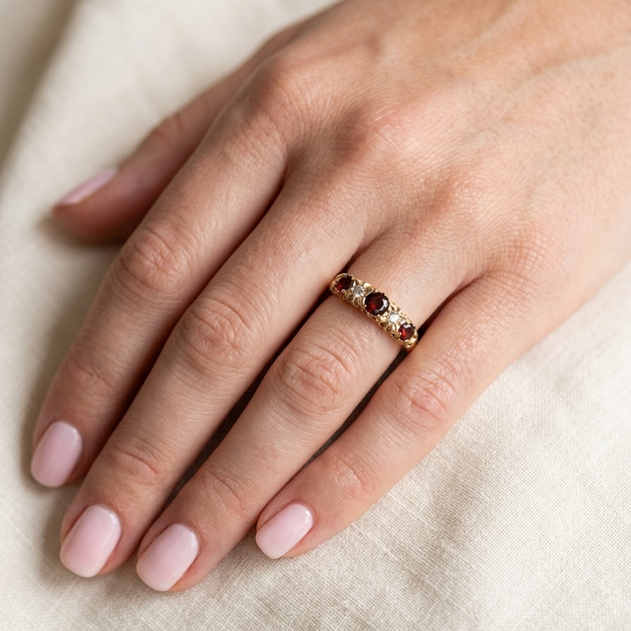 hand A vintage style 18 carat gold boat shaped ring. Features three dark red garnets, centre 4mm, each end a 3mm stone. 