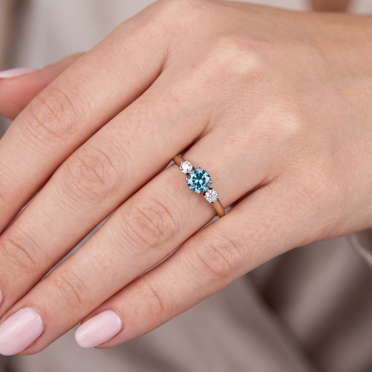 hand A vintage three stone ring. Features to the centre a 6mm natural blue zircon, 6mm diameter, claw set.